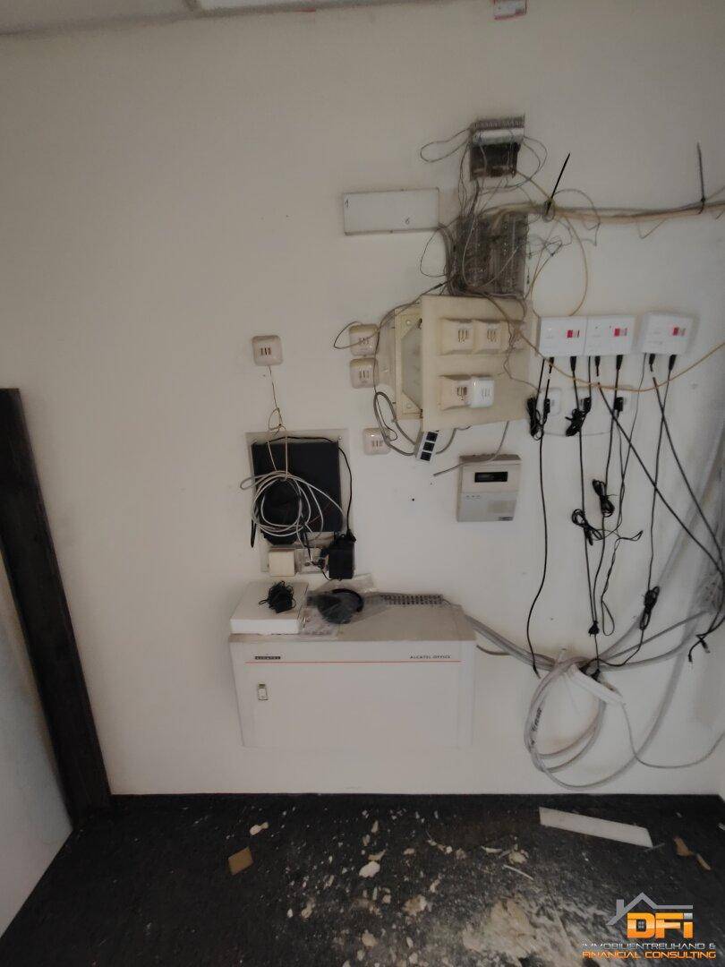 Technikraum mit vielen Kabeln und Installationen, der auf eine Renovierung oder Modernisierung wartet.