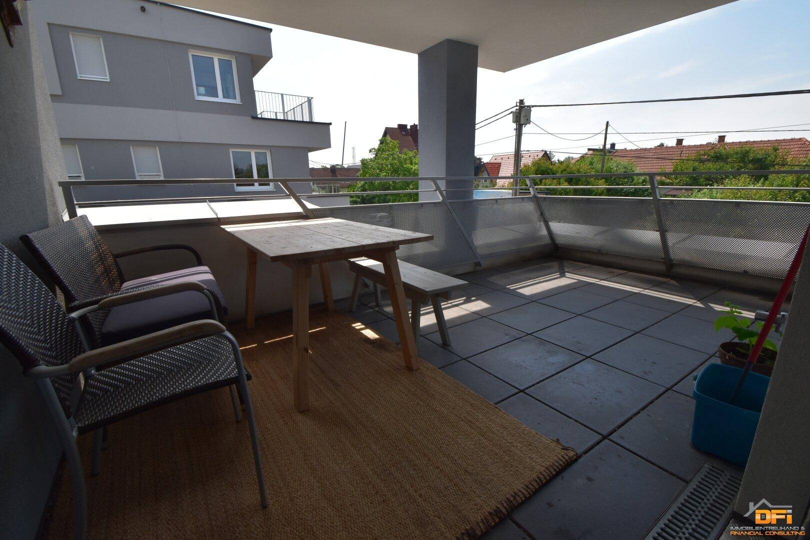 Geräumiger Balkon mit Fliesenboden und einfacher Sitzgelegenheit, ideal für entspannte Stunden im Freien.