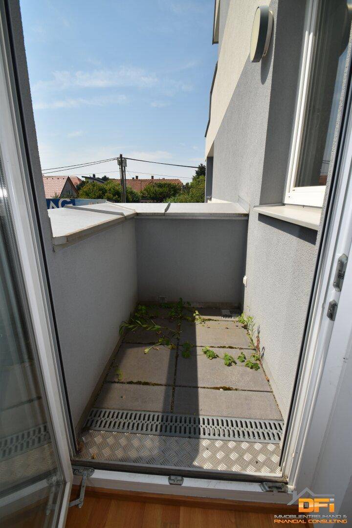 Kleiner, gefliester Balkon mit begrenztem Platz, der noch etwas Pflege benötigt.