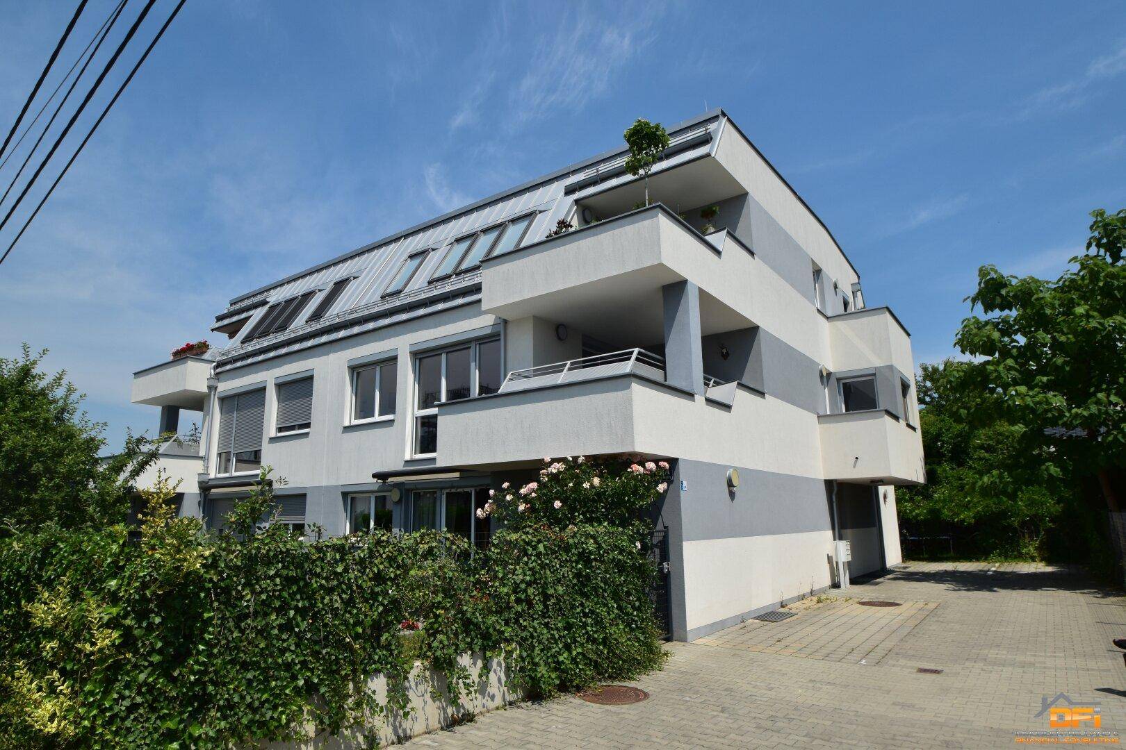 Moderne Wohnanlage mit mehreren Balkonen und einer ansprechenden Fassadengestaltung unter blauem Himmel.