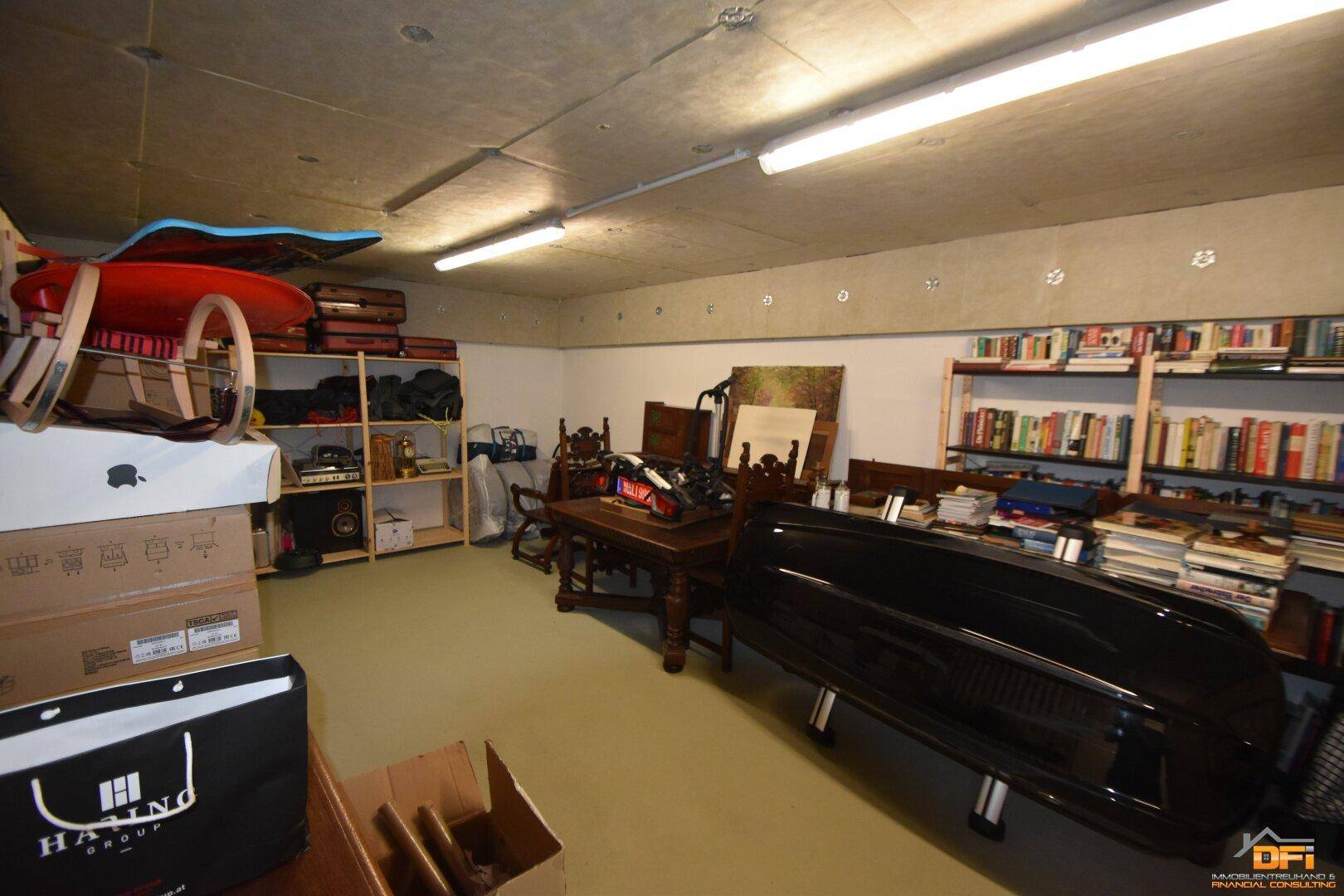 Geräumiger Kellerraum mit Regalen, Büchern und verschiedenen Gegenständen für zusätzlichen Stauraum.