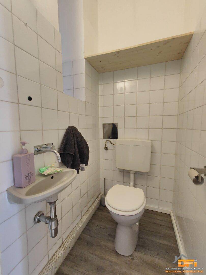 Kleines Gäste-WC mit Waschbecken und Toilette, einfach gefliest.