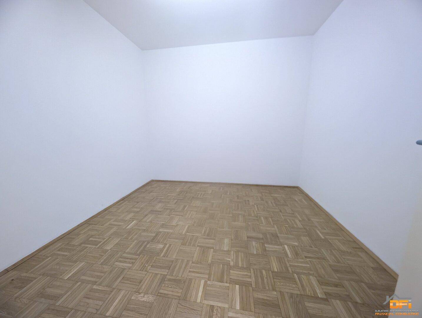 Kleiner, leerer Raum mit Parkettboden und weißen Wänden, geeignet als Einzelbüro.
