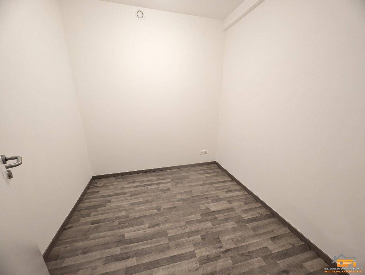Kleiner, leerer Raum mit hellem Holzoptikboden und weißen Wänden, ideal als Abstellraum.