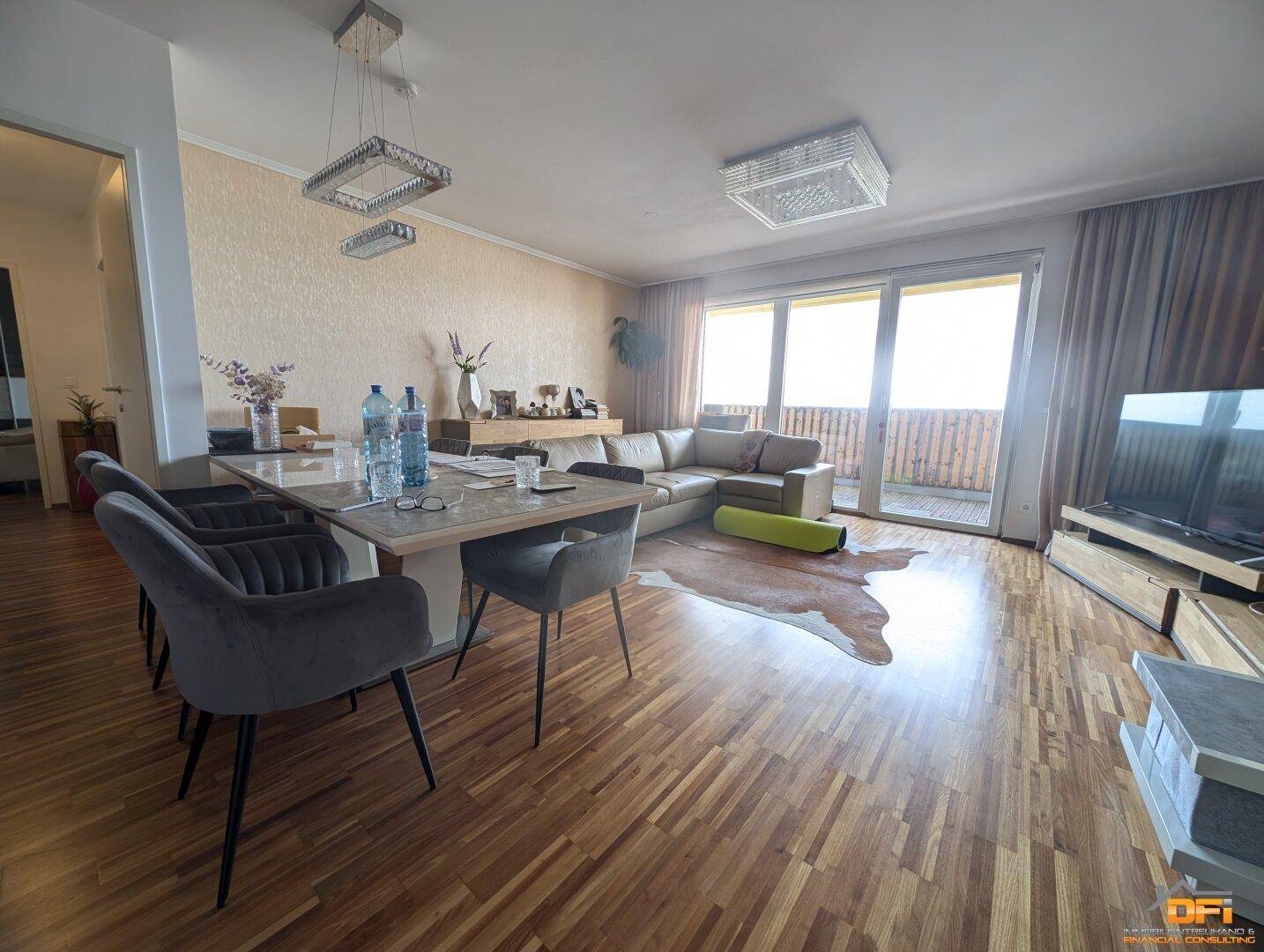 Essbereich mit großem Tisch, bequemer Sitzecke und direktem Zugang zum sonnigen Balkon.
