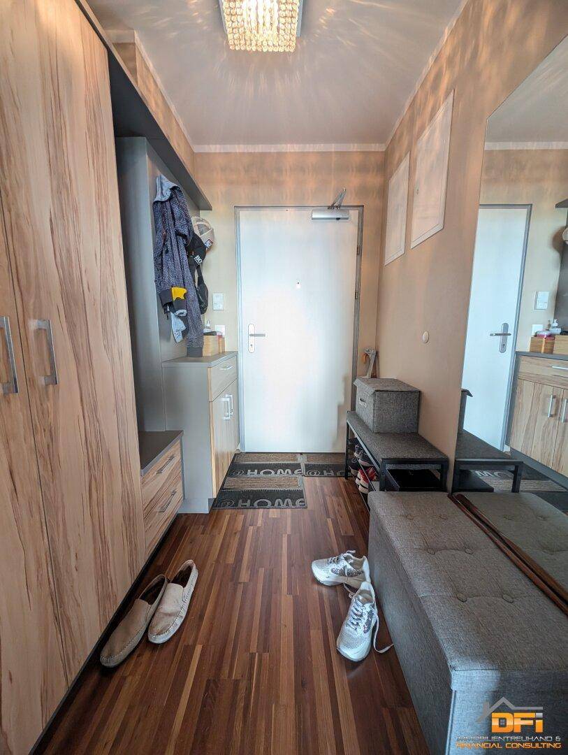 Eingangsbereich mit Garderobe, Spiegel und praktischen Schuhablagen, hell und einladend.