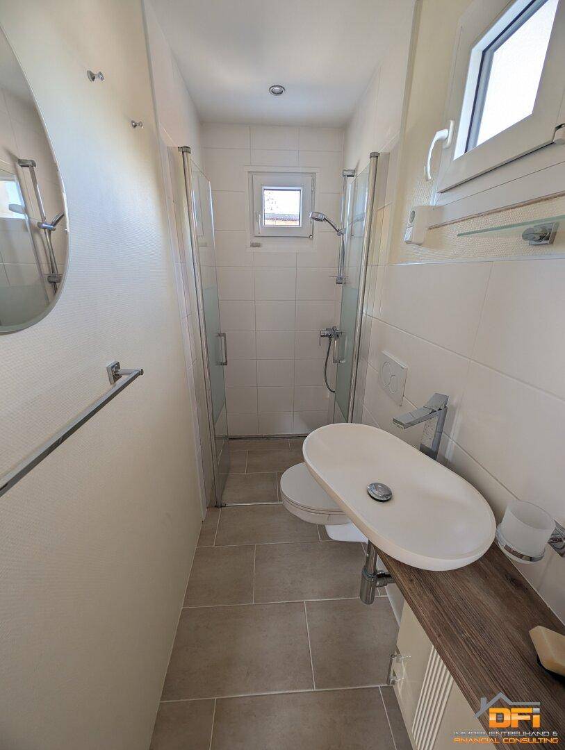 Modernes Badezimmer mit Dusche, Hänge-WC und Waschbecken auf Holzkonsole.