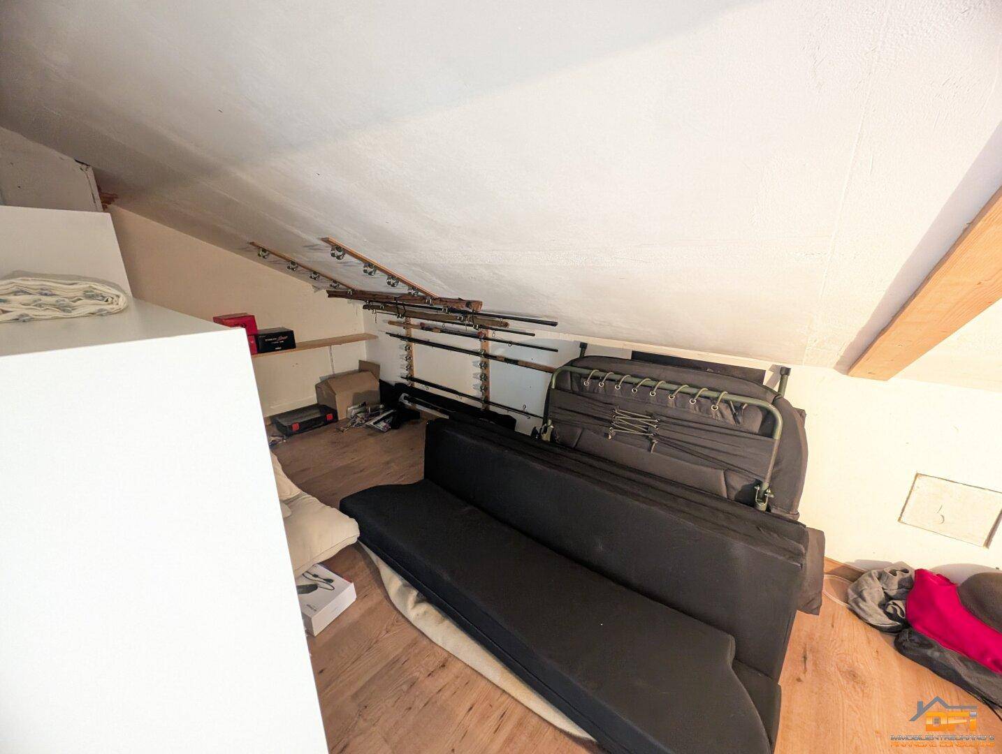 Abstellraum im Dachgeschoss mit Schrägen und gelagerten Gegenständen.