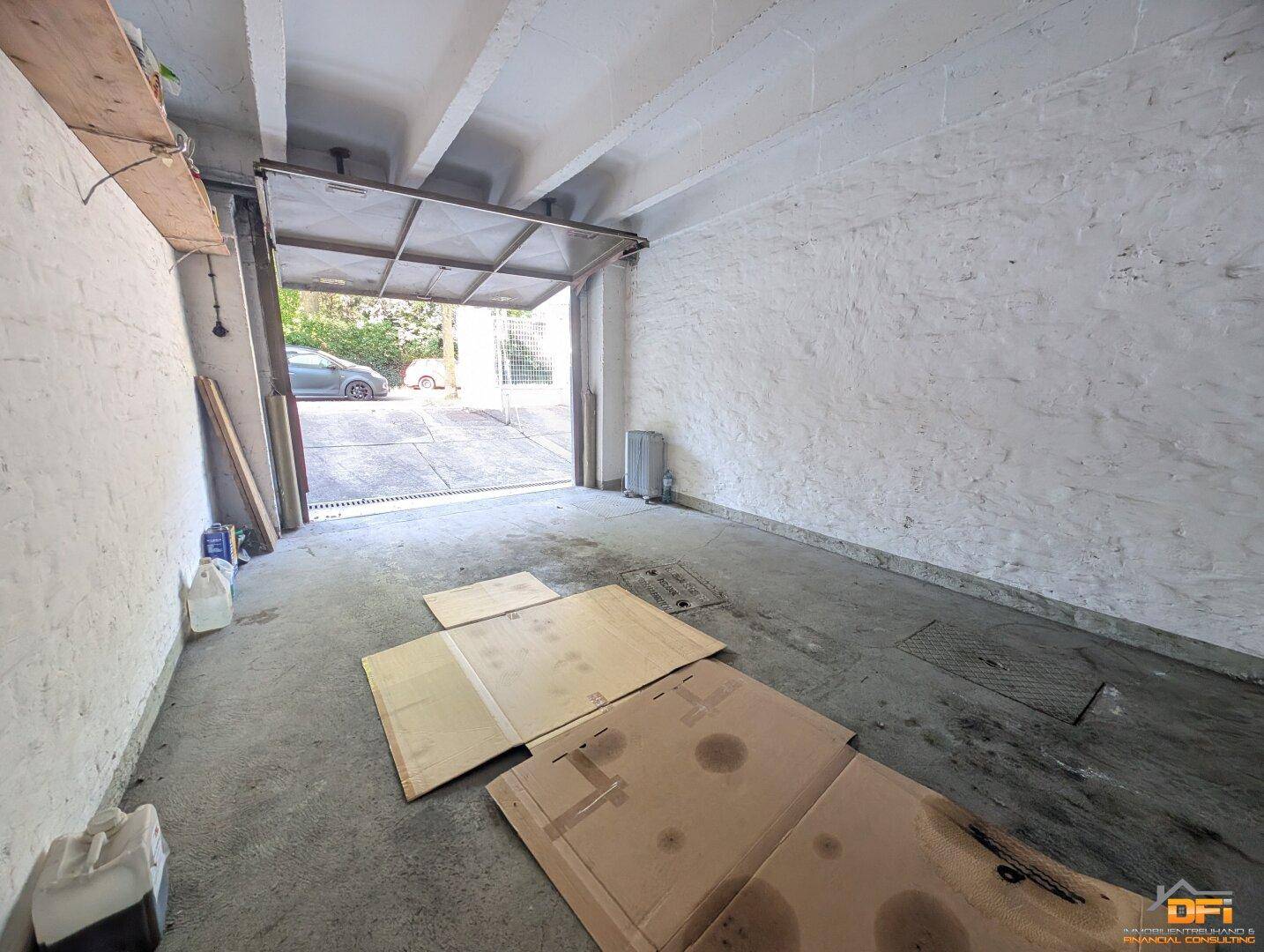 Geräumige Garage mit Betonboden und offenem Tor, bereit zur Nutzung und Lagerung.
