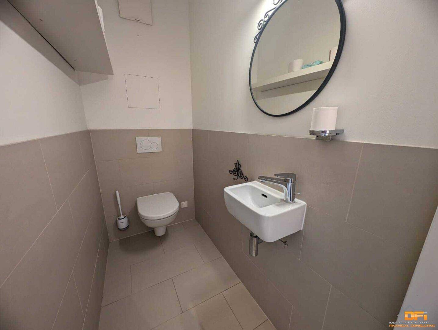 Separates Gäste-WC mit Wand-WC und kleinem Waschbecken.