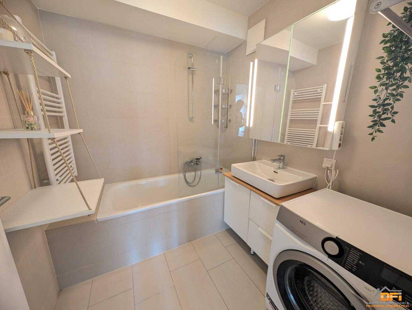 Modernes Badezimmer mit Badewanne, Waschbecken und Waschmaschine.
