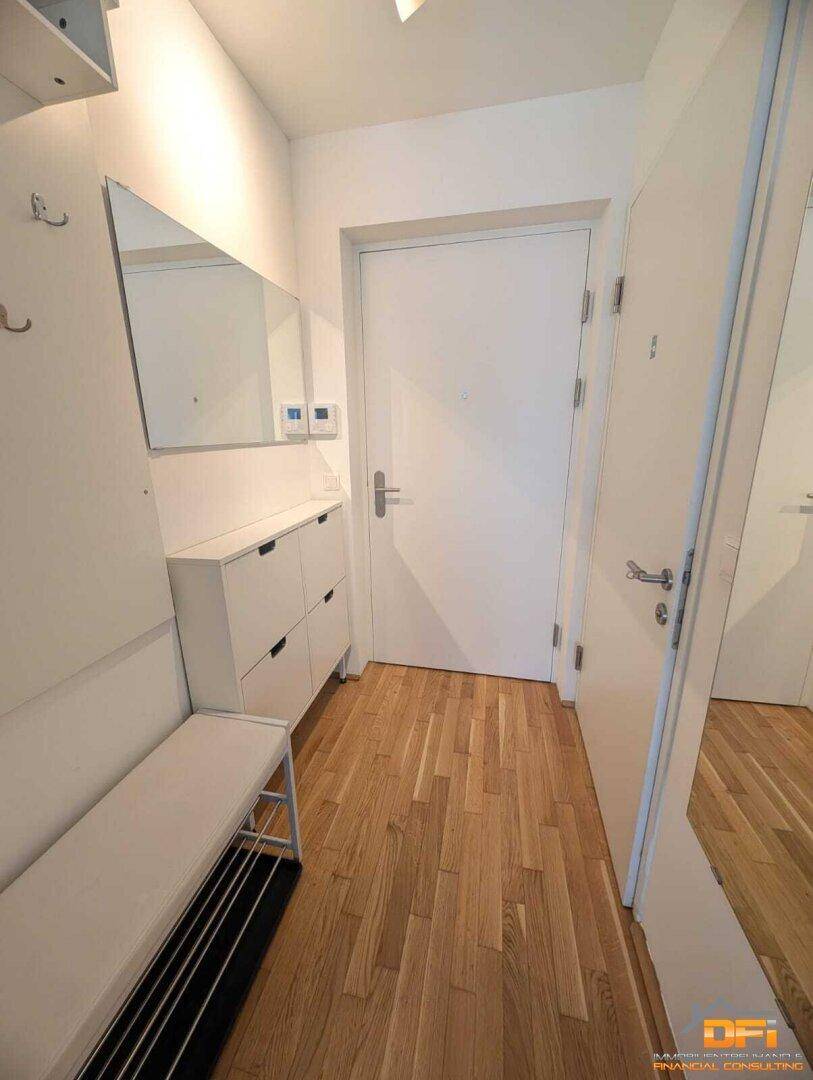 Eingangsbereich mit Garderobe, Schuhschrank und Spiegel, hell und einladend.