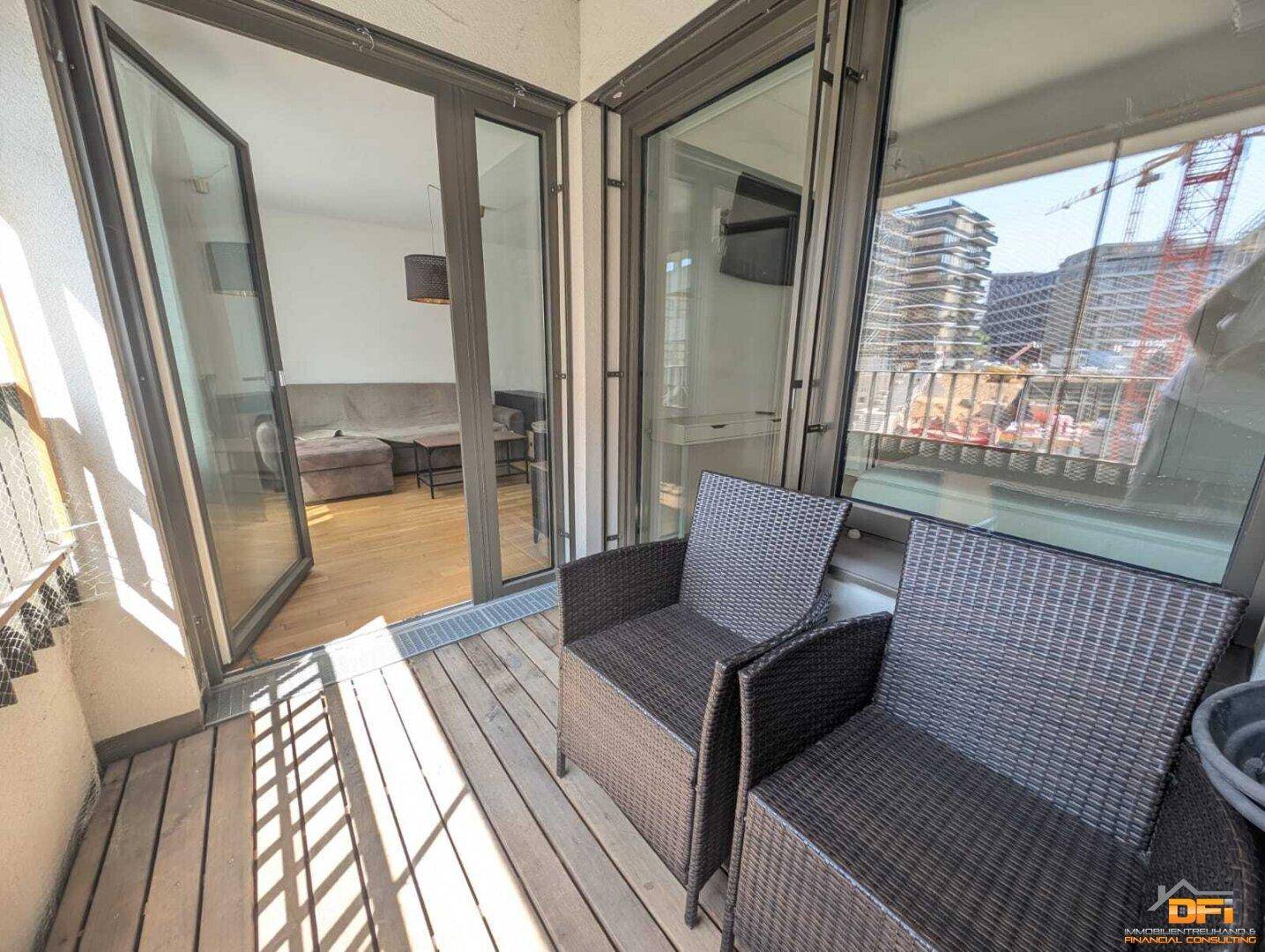 Balkon mit Holzboden und Sitzgelegenheiten, bietet einen Blick auf die Umgebung.