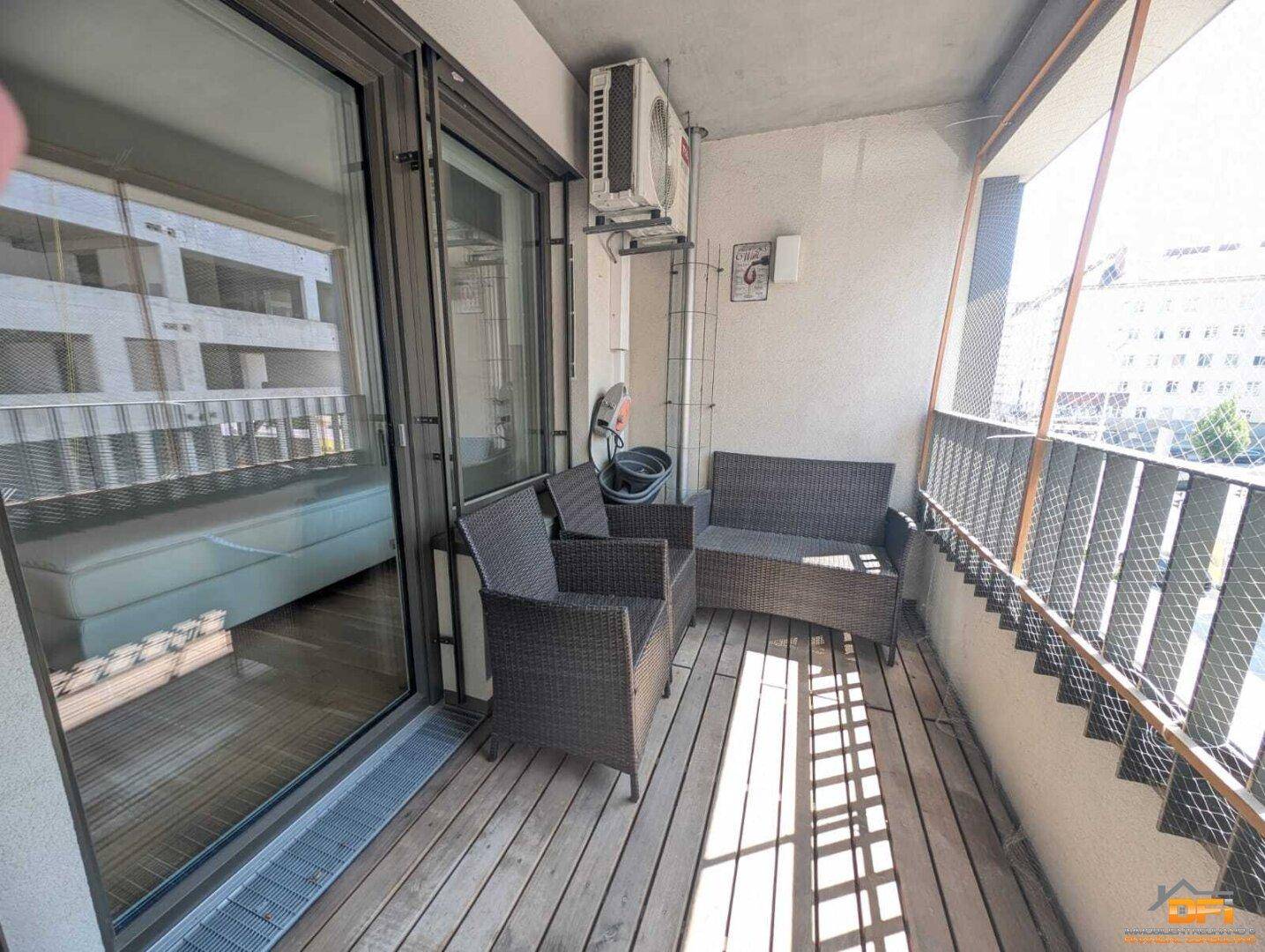 Geräumiger Balkon mit Sitzmöbeln und Klimaanlage, ideal zum Entspannen im Freien.