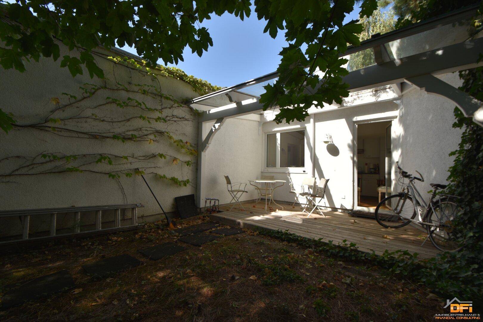Kleine, überdachte Terrasse mit Sitzgelegenheiten und Zugang zum Innenbereich.