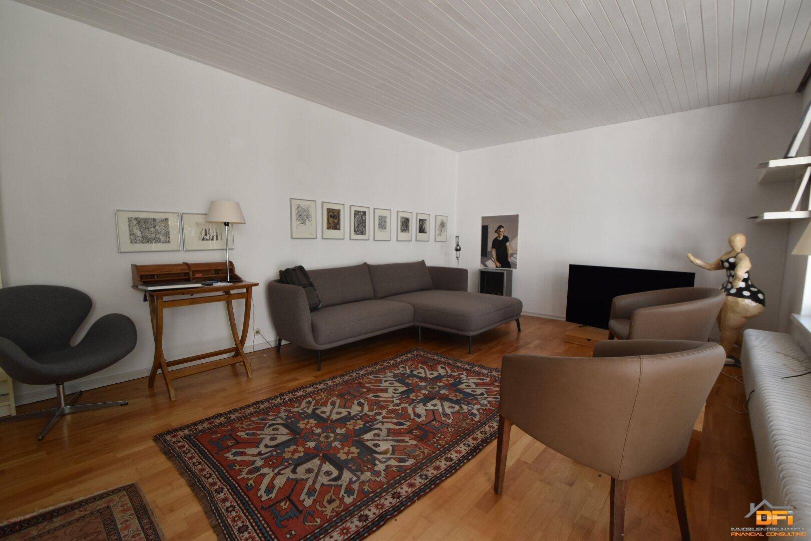 Gemütliches Wohnzimmer mit Sofa, Teppich und Holzboden.