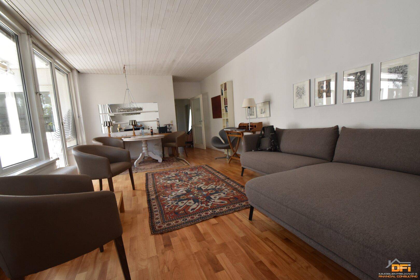 Heller Wohn- und Essbereich mit Holzboden und modernem Sofa.