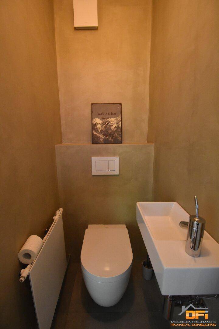 Kleines Gäste-WC mit wandhängender Toilette und modernem Waschbecken.