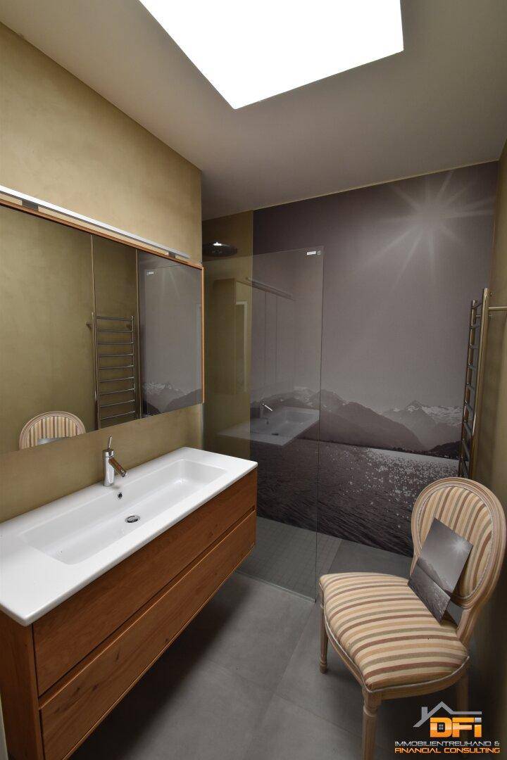 Modernes Badezimmer mit Einzelwaschbecken, Spiegelschrank und begehbarer Dusche.