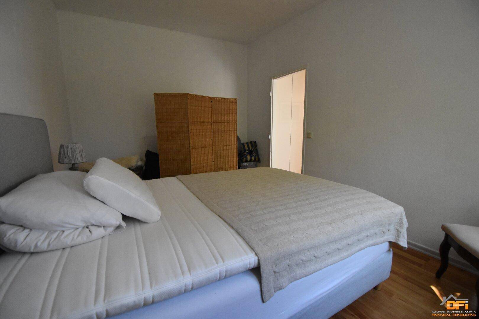Schlafzimmer mit Doppelbett, Holzboden und schlichtem Design.