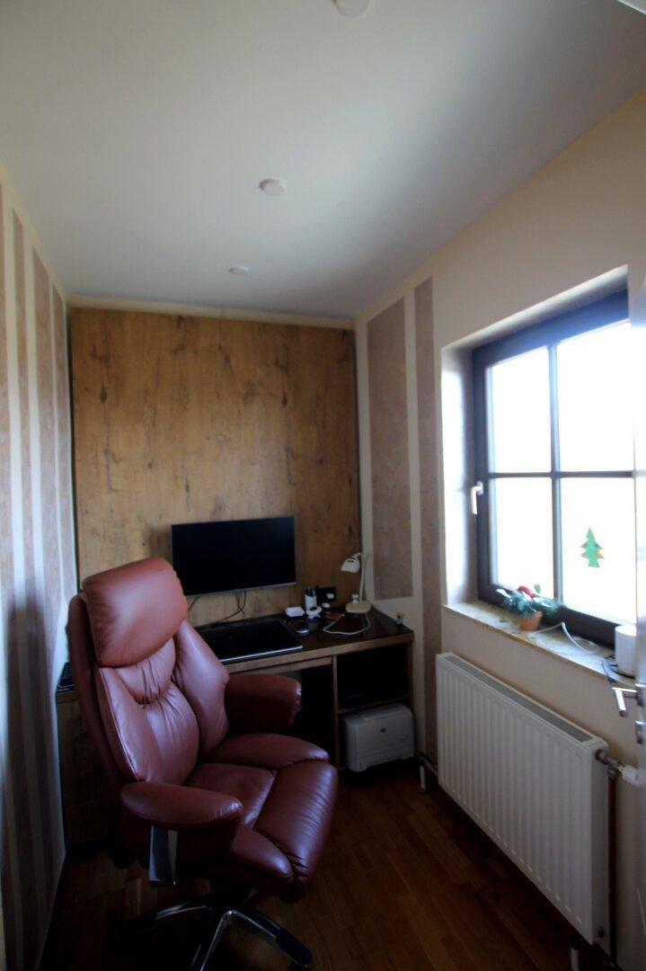 Kleines Arbeitszimmer mit Schreibtisch, Bürostuhl und Fenster mit Blick ins Grüne.