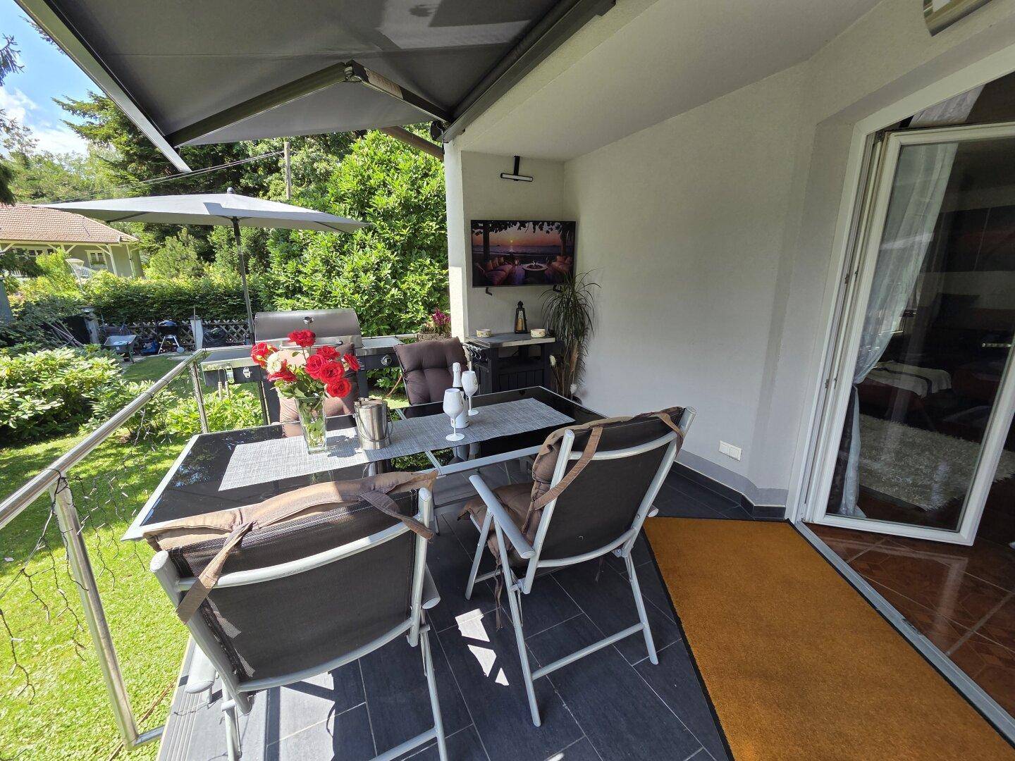 Geräumiger Balkon mit Grillbereich, Esstisch und Außenfernseher für gesellige Abende.