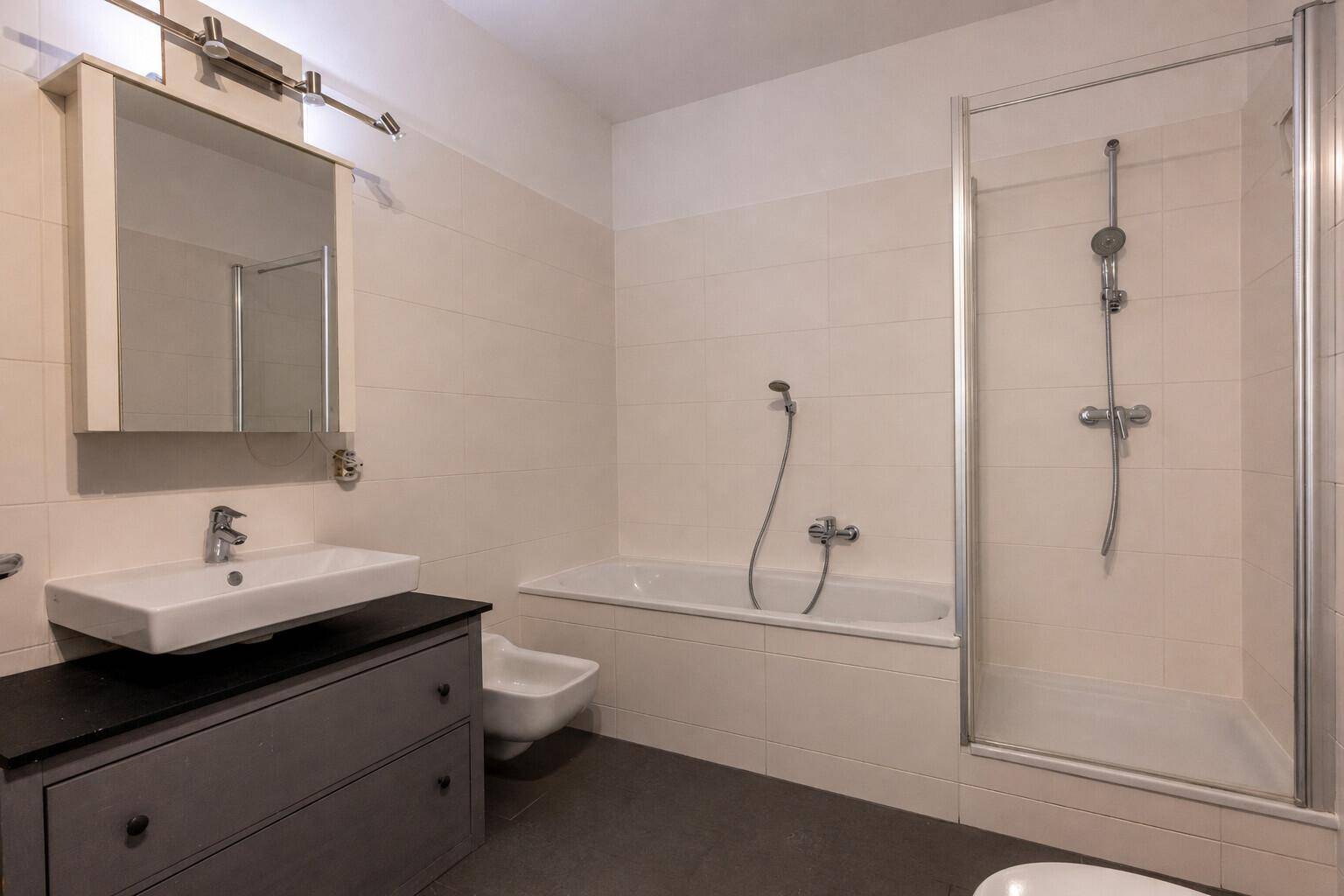 Modernes Badezimmer mit Badewanne, Dusche, Einzelwaschbecken und Bidet.