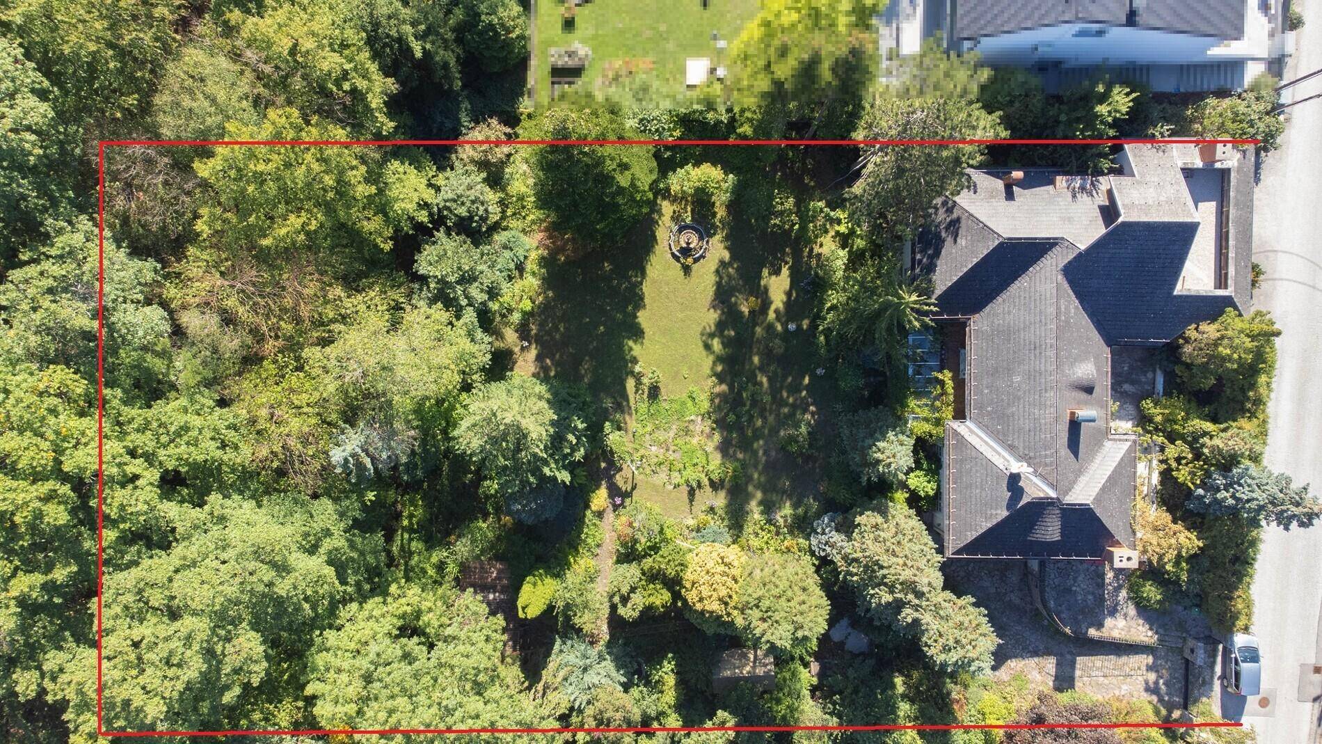 Luftaufnahme des Anwesens mit großem Garten, altem Baumbestand und umrandetem Grundstück.