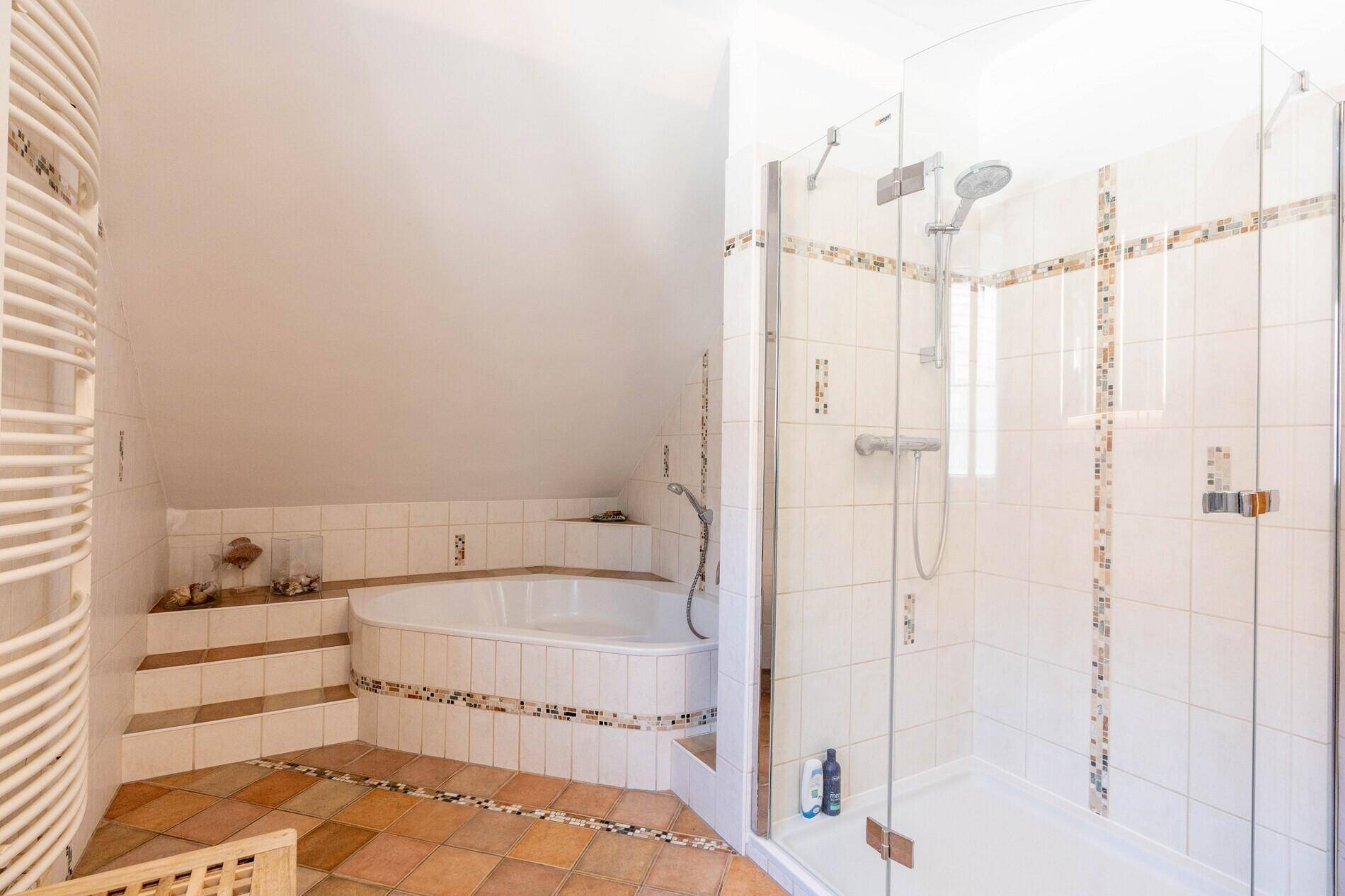 Helles Badezimmer mit Eckbadewanne, separater Dusche und Fliesenboden.