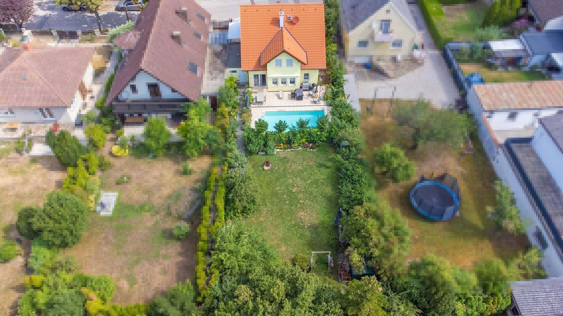 Luftaufnahme des Anwesens mit Haus, Swimmingpool und weitläufigem Gartenbereich.