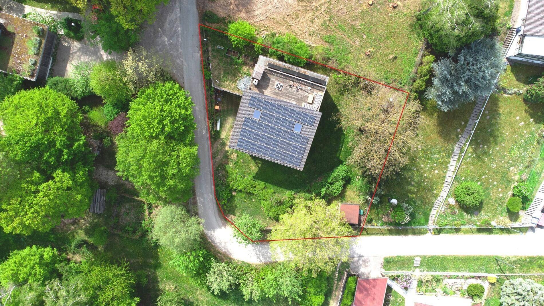 Luftaufnahme des Grundstücks mit Haus, Solaranlage auf dem Dach und viel Grün.
