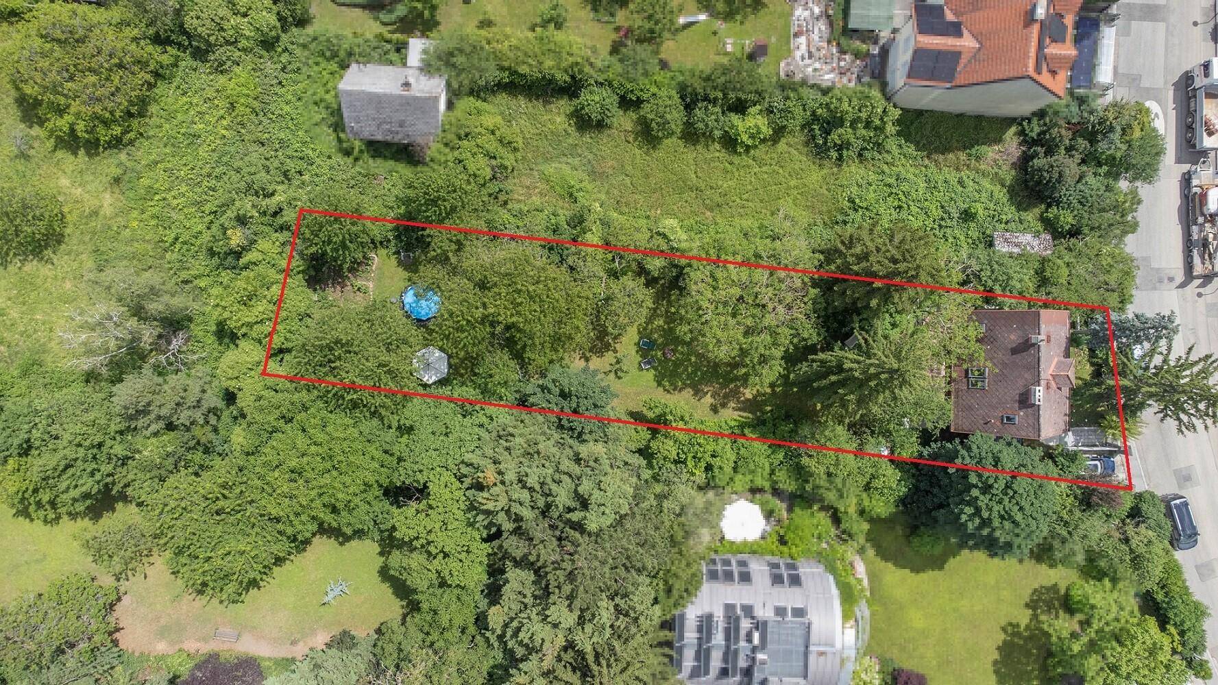 Luftaufnahme des Grundstücks mit Wohnhaus, großem Garten und angrenzender Nachbarschaft.