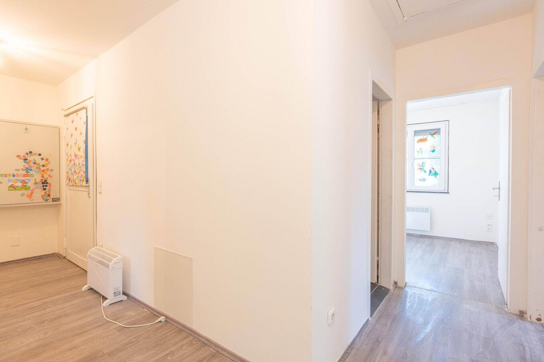 Heller Flur mit Laminatboden und Zugang zu weiteren Zimmern im Haus.