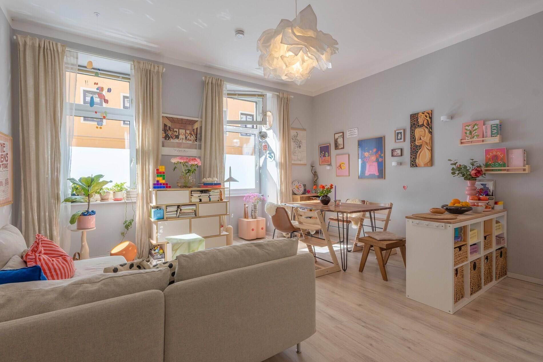 Offener Wohn- und Essbereich mit hellem Laminatboden, Esstisch und gemütlichem Sofa.
