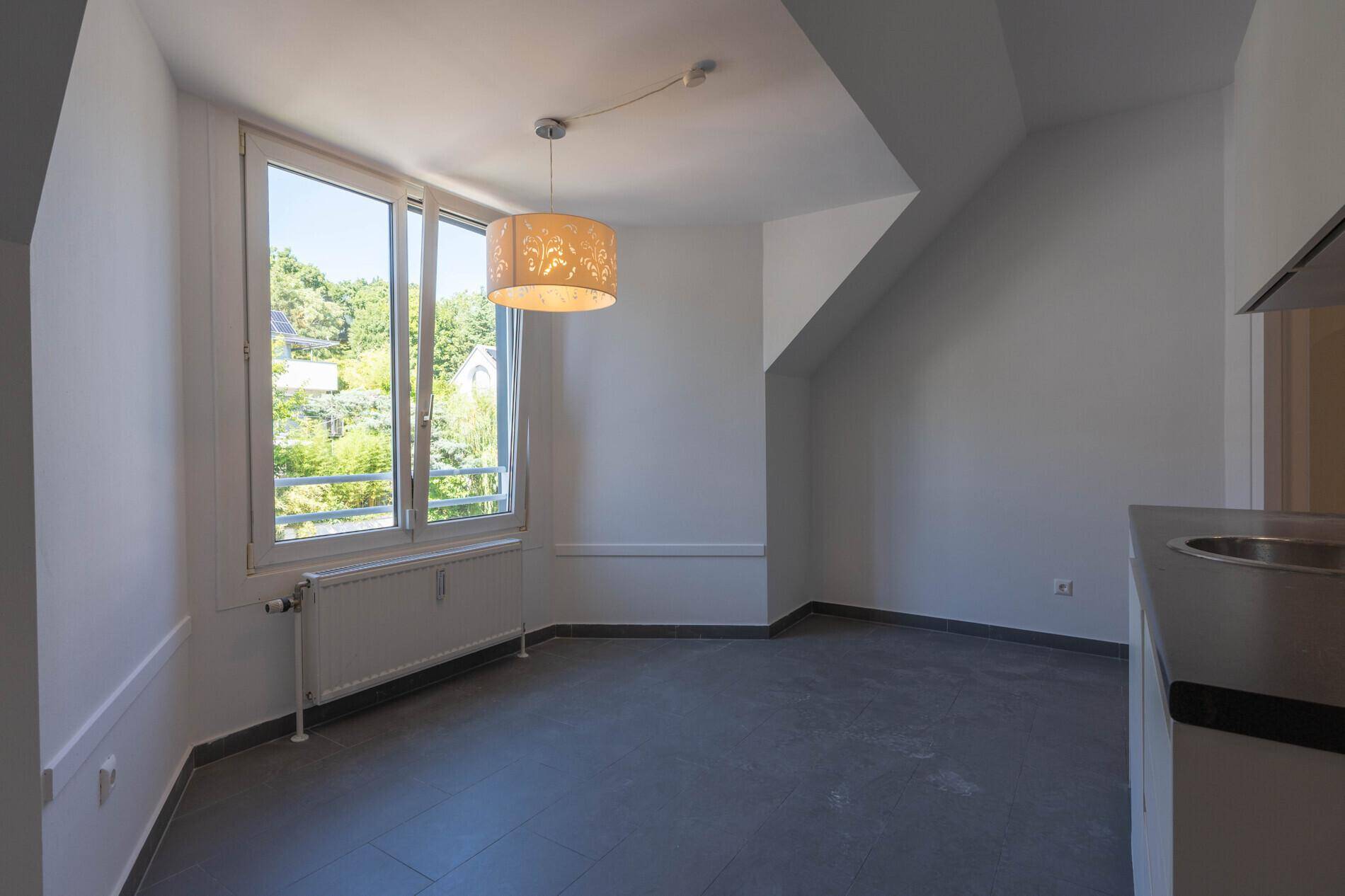 Heller Essbereich in der Küche mit großem Fenster und Blick ins Grüne.