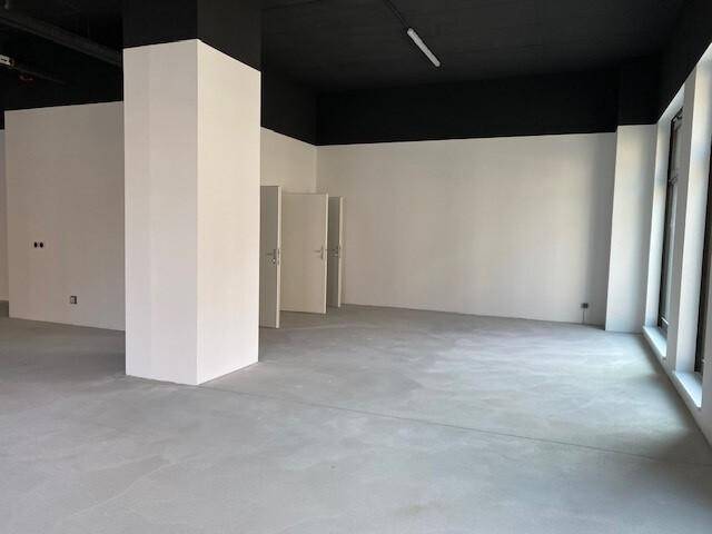 Geräumiger, leerer Innenraum mit hohen Decken, weißen Wänden und Betonboden, ideal für individuelle Gestaltung.