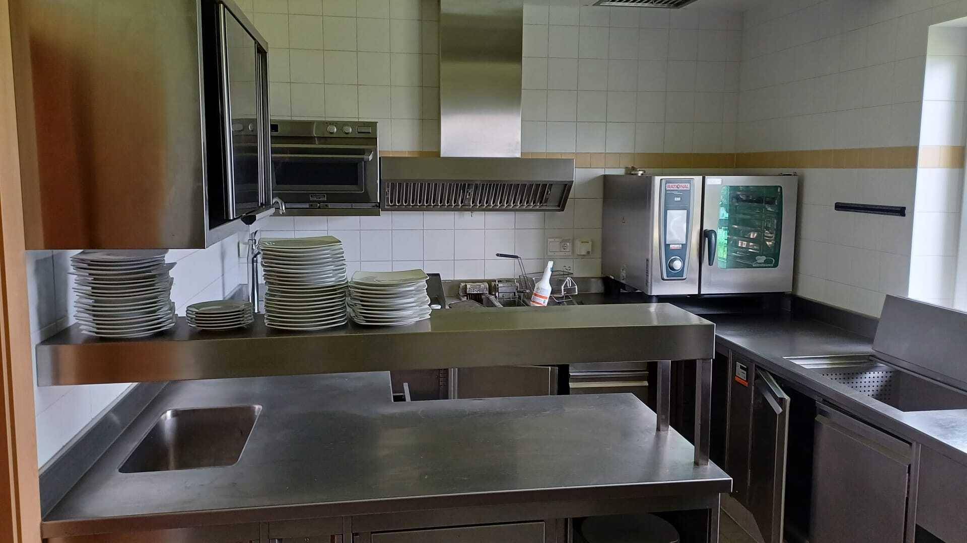 Professionelle Edelstahlküche mit Spülbecken, Arbeitsflächen und modernen Geräten für den Gastronomiebetrieb.