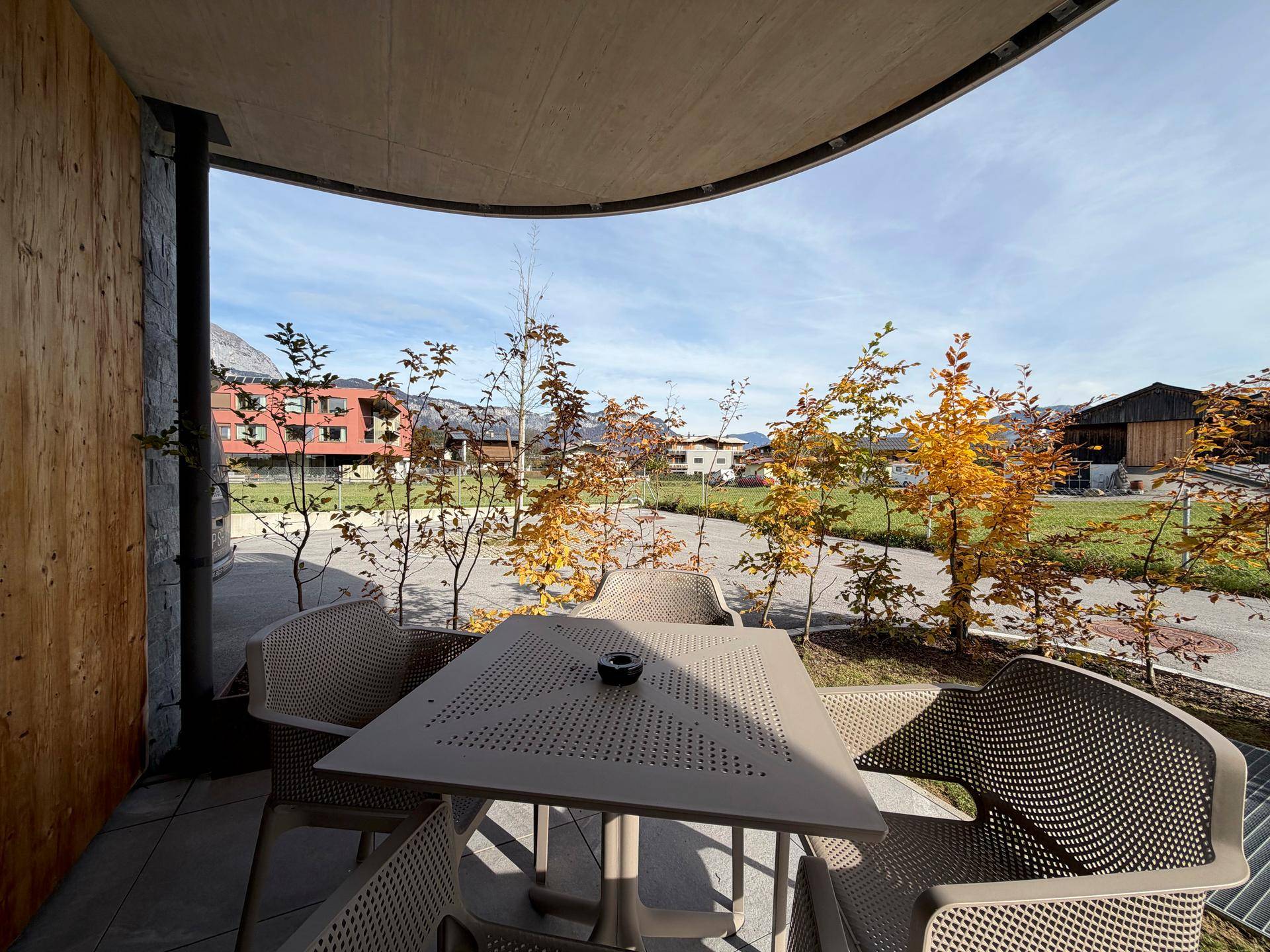 Überdachte Terrasse mit Sitzgelegenheiten und Blick auf die umliegende Berglandschaft.