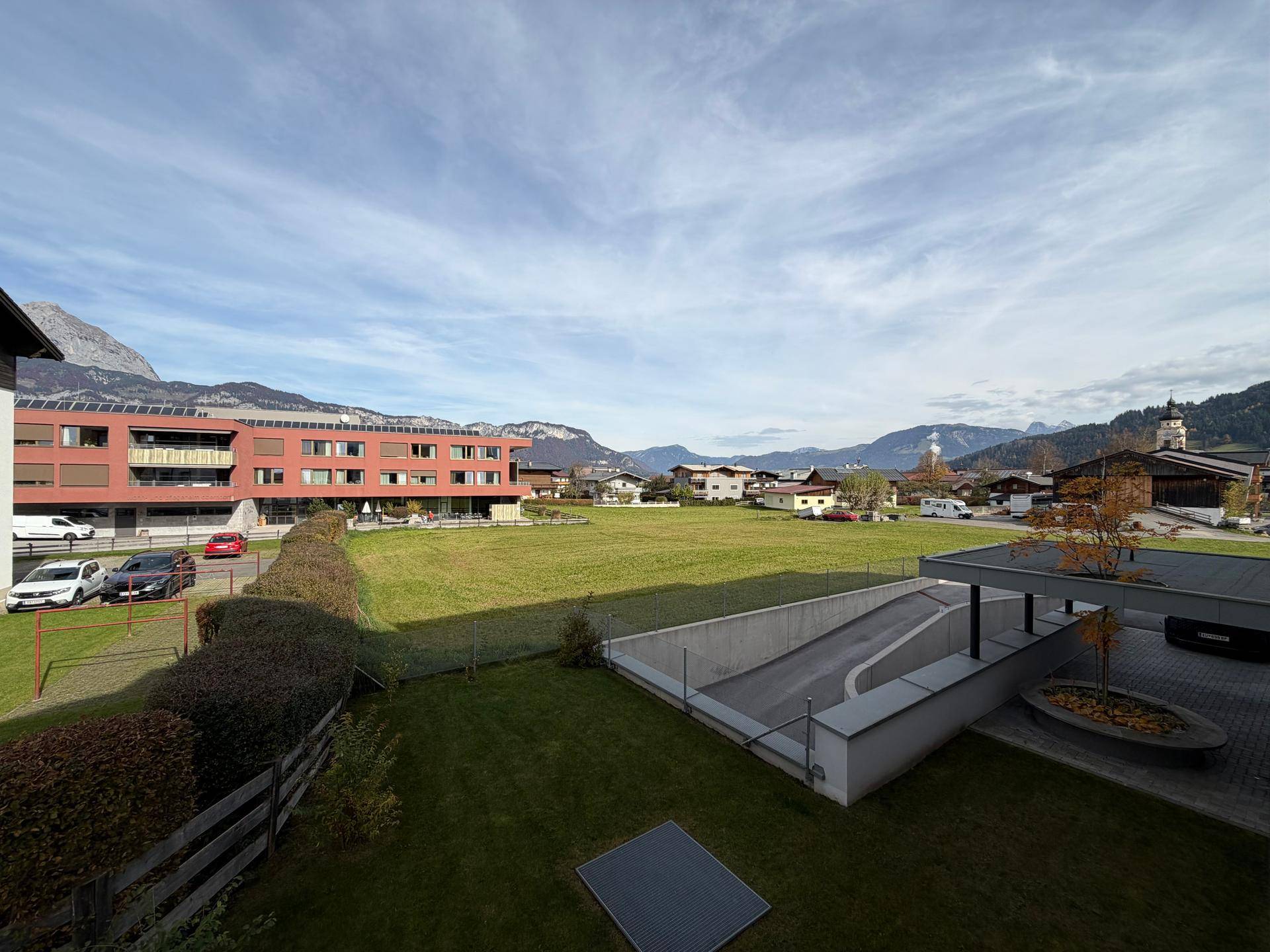 Weitläufiger Blick auf die grüne Landschaft, Berge und umliegende Gebäude.