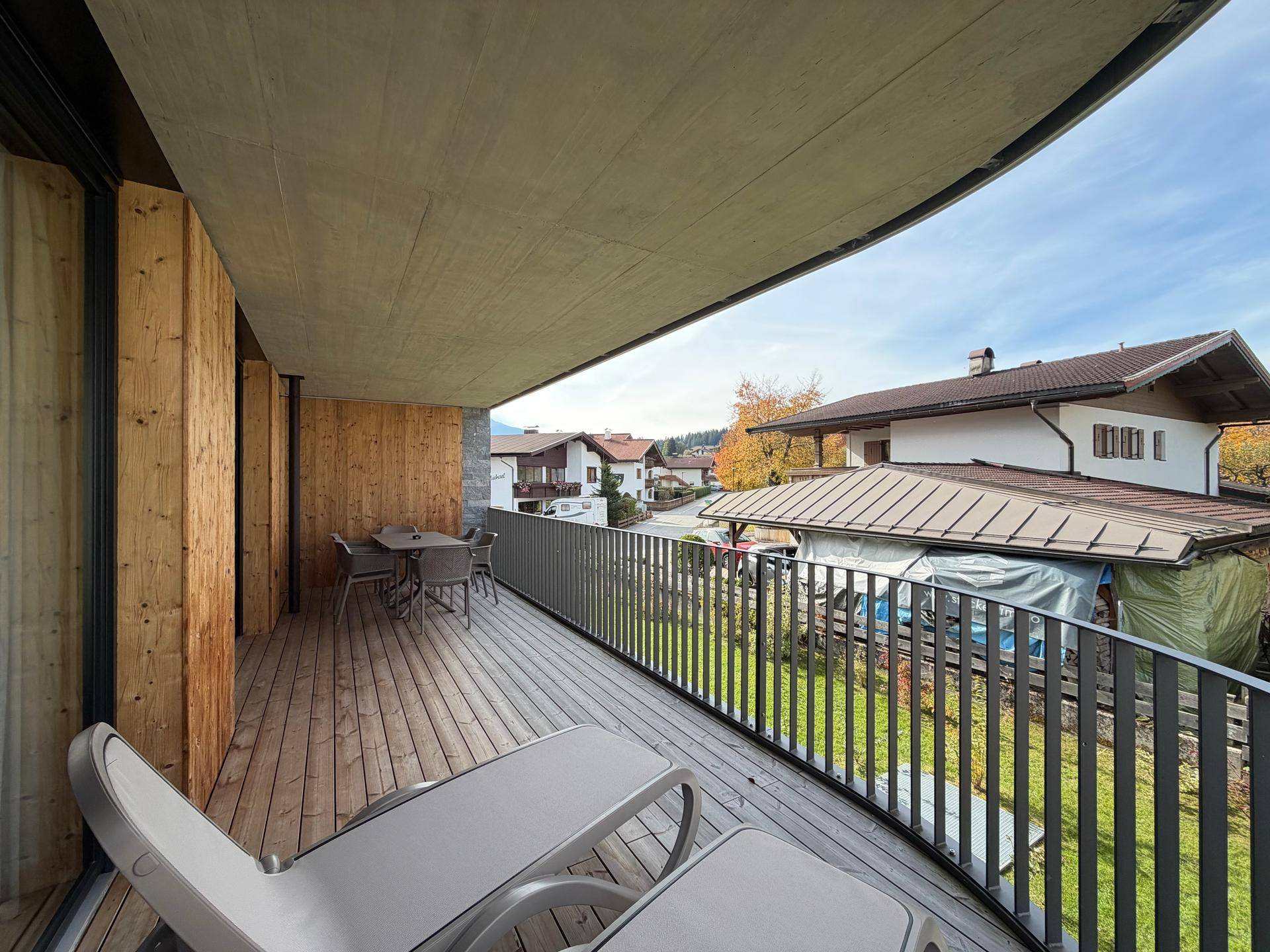 Breiter Balkon mit Holzboden und Liegestühlen, bietet einen schönen Ausblick.