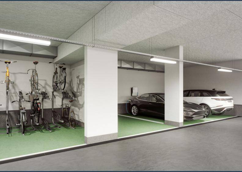 Tiefgarage mit Stellplätzen für Autos, Fahrradständern und einer Ladestation für Elektrofahrzeuge.