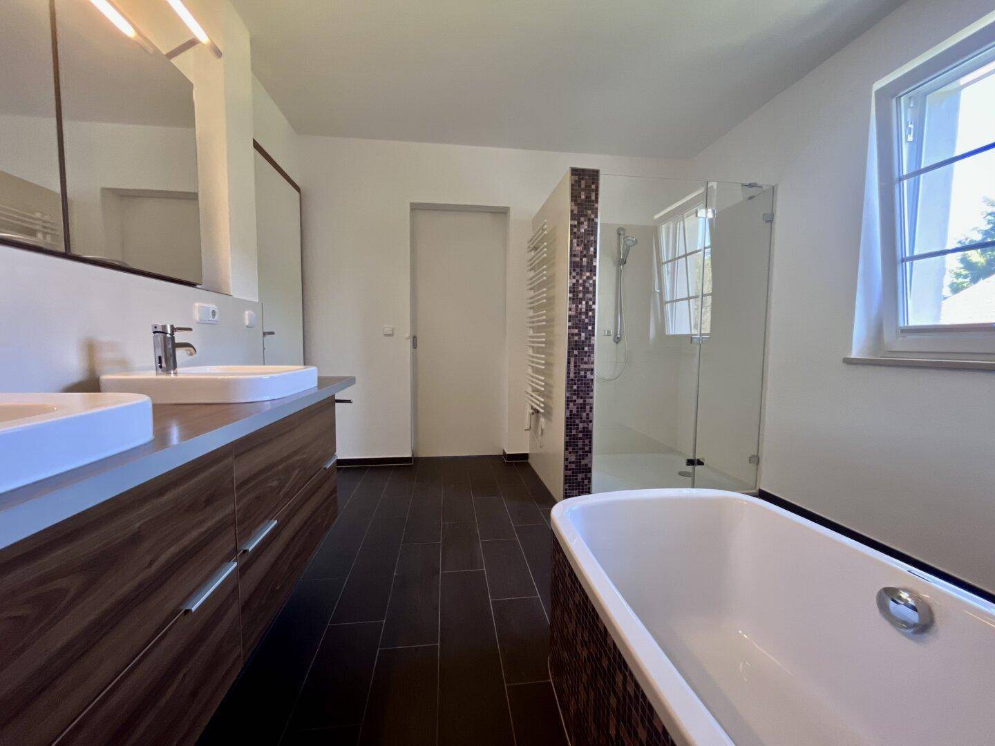 Modernes Badezimmer mit Doppelwaschbecken, Badewanne und begehbarer Dusche.