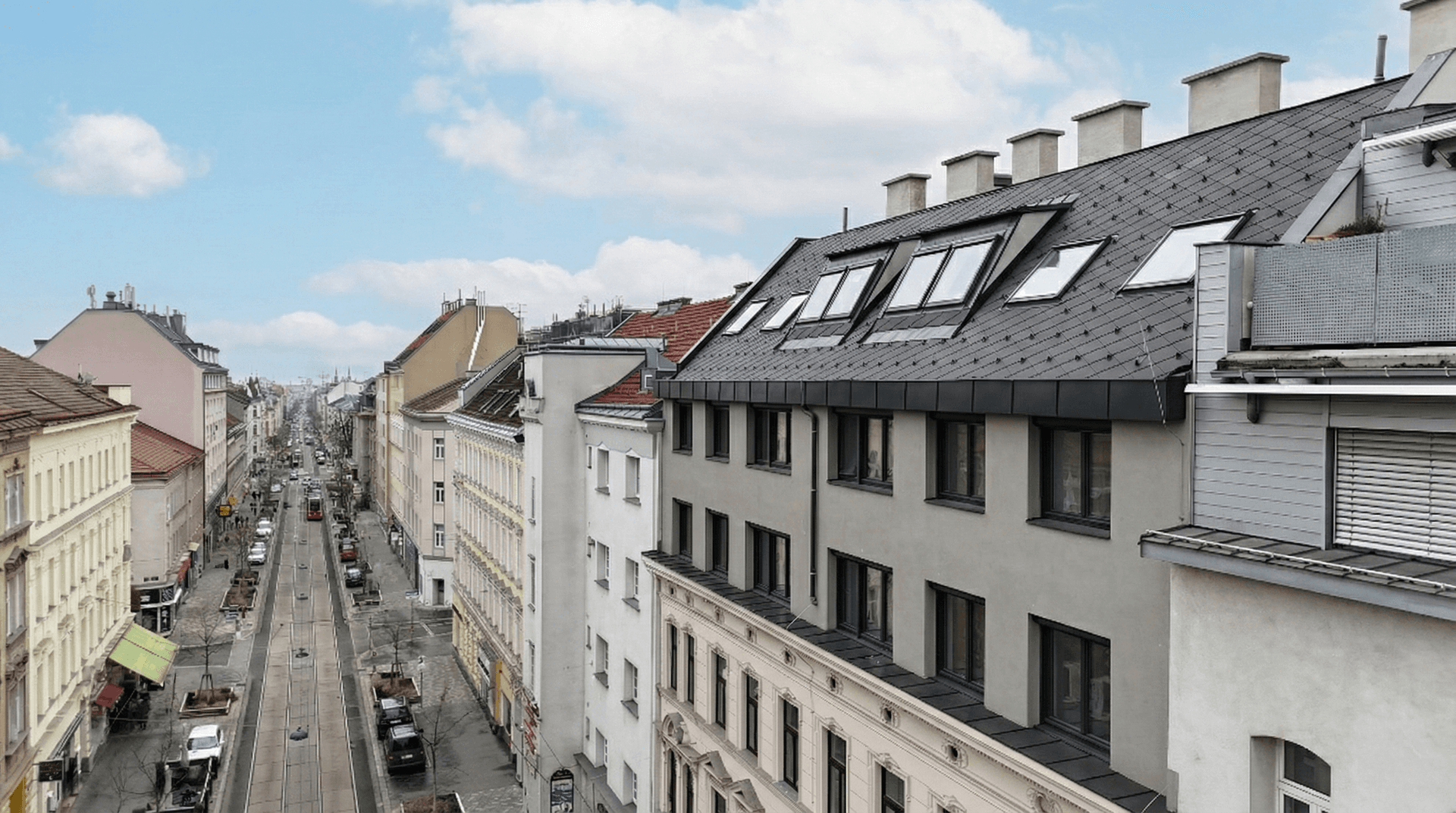 Blick über die Dächer einer Stadtstraße mit historischen und modernen Gebäuden.