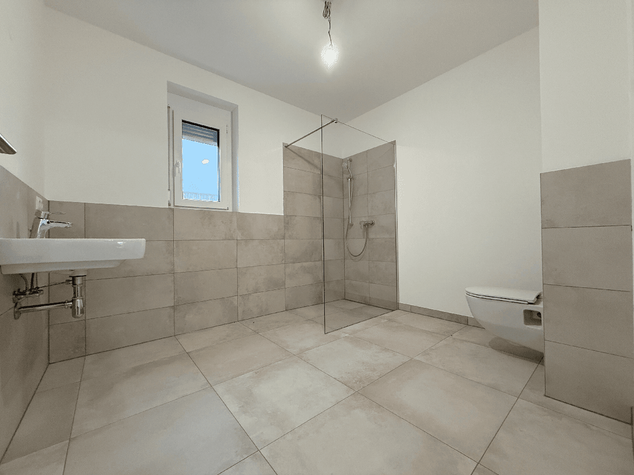 Modernes Badezimmer mit ebenerdiger Dusche, Wand-WC und Fenster.