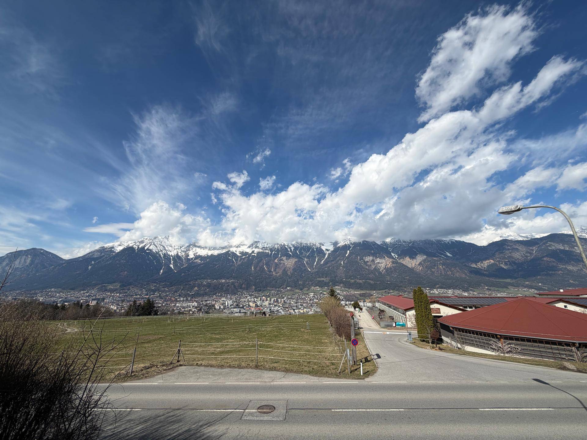 Panoramablick auf die schneebedeckten Berge und die Stadt in der Ferne unter blauem Himmel.