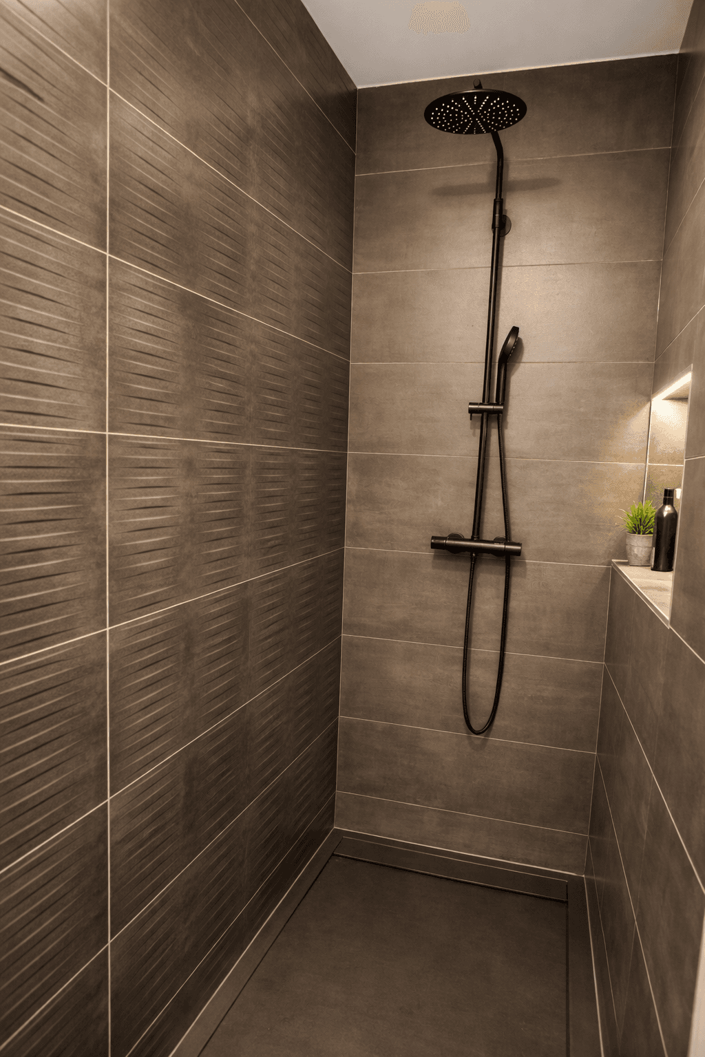 Moderne Duschkabine mit dunklen Fliesen und einer luxuriösen Regendusche.