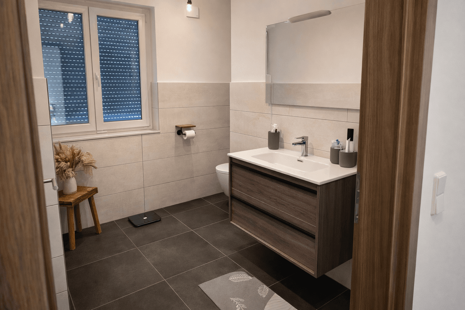 Helles Badezimmer mit modernem Waschtisch, Toilette und Fenster für natürliche Belüftung.