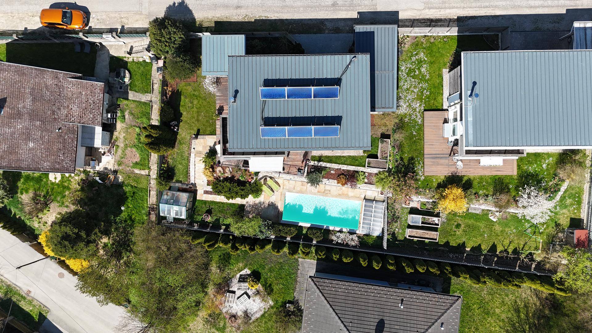 Luftaufnahme des Anwesens mit Haus, Garten, Pool und Photovoltaikanlage auf dem Dach.