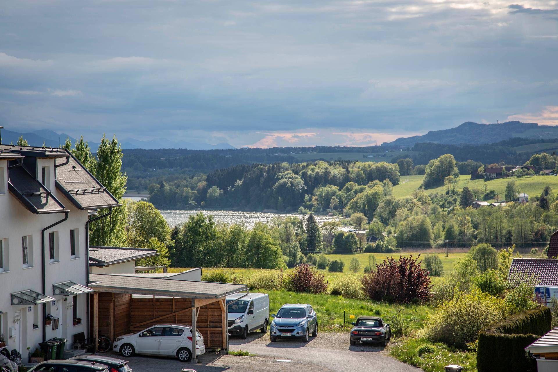 Panoramablick auf die umliegende Landschaft mit See, Wäldern und fernen Bergen.