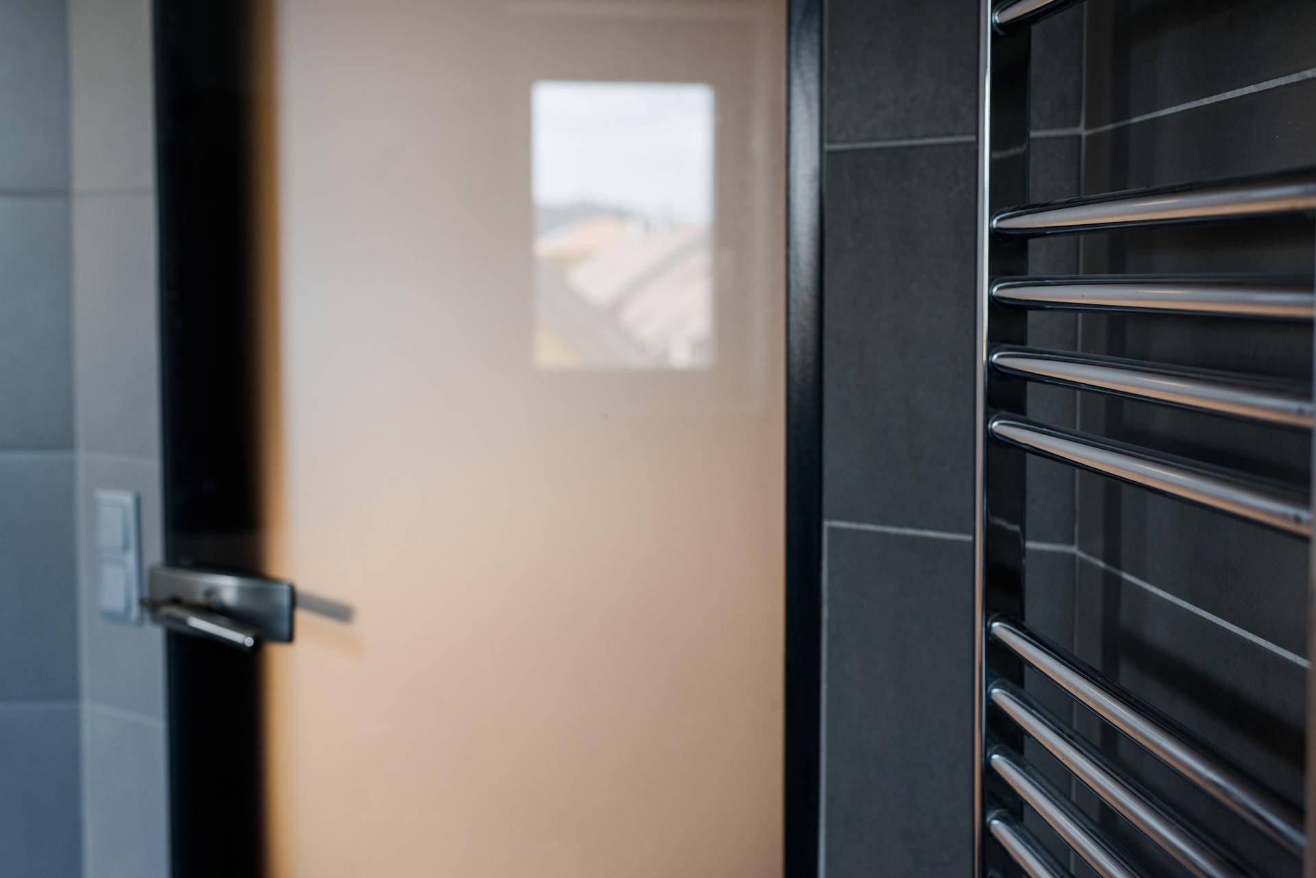 Beheizter Handtuchhalter im modernen Badezimmer mit Fenster im Hintergrund.